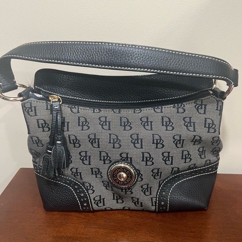 Dooney & Burke black logo printed fabric with black pebbled leather accents.